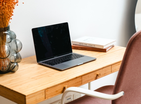 Minimalist desk with a laptop and decor, no people visible.